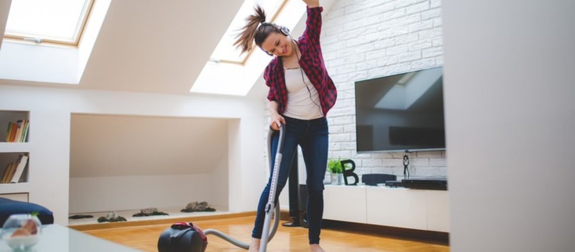 Beautiful brunette woman, cleaning her home while listening to music.